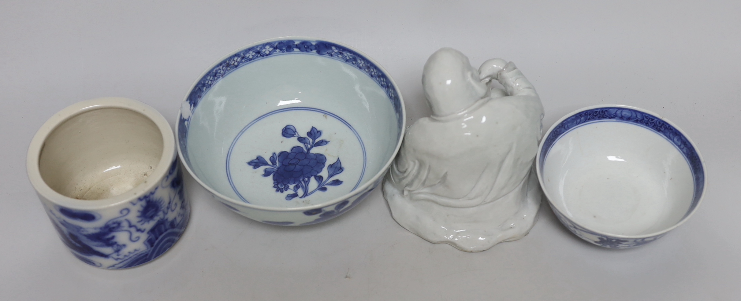 A Chinese pottery figure of a Sage, a blue and white brush pot and two bowls, sage 16cm high